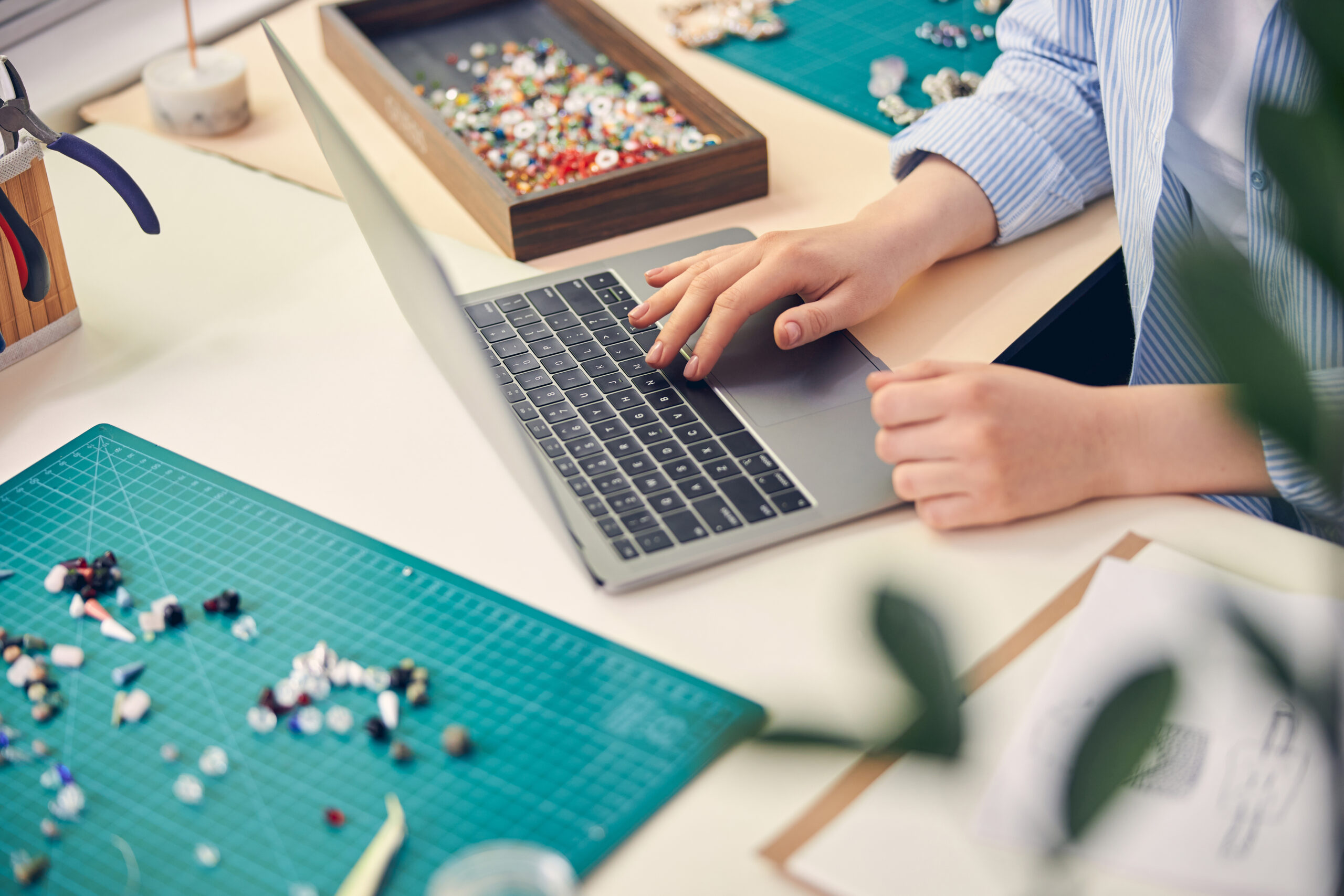 A woman is using task management software on a laptop at a desk.