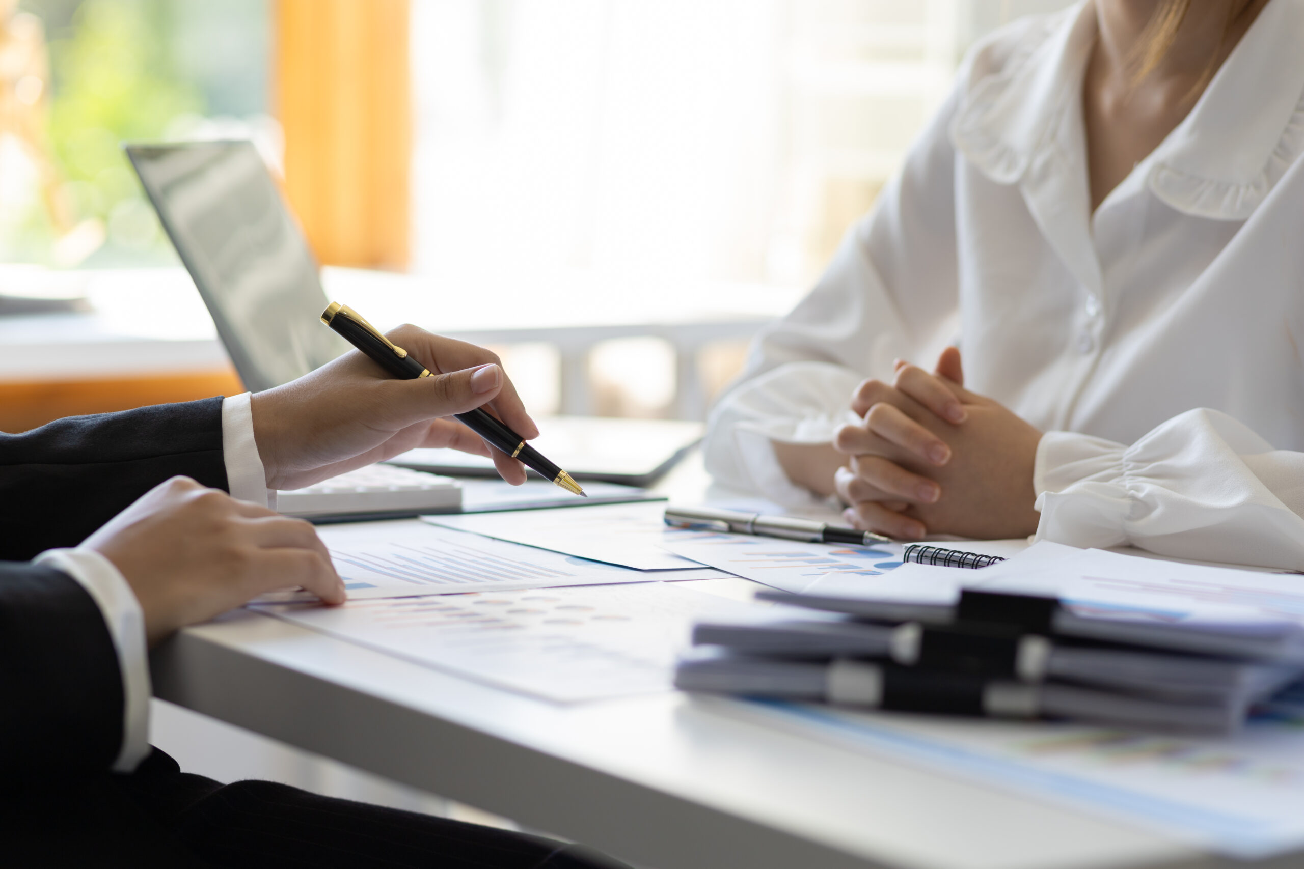 A man and woman utilizing different types of inventory management software while sitting at a desk.