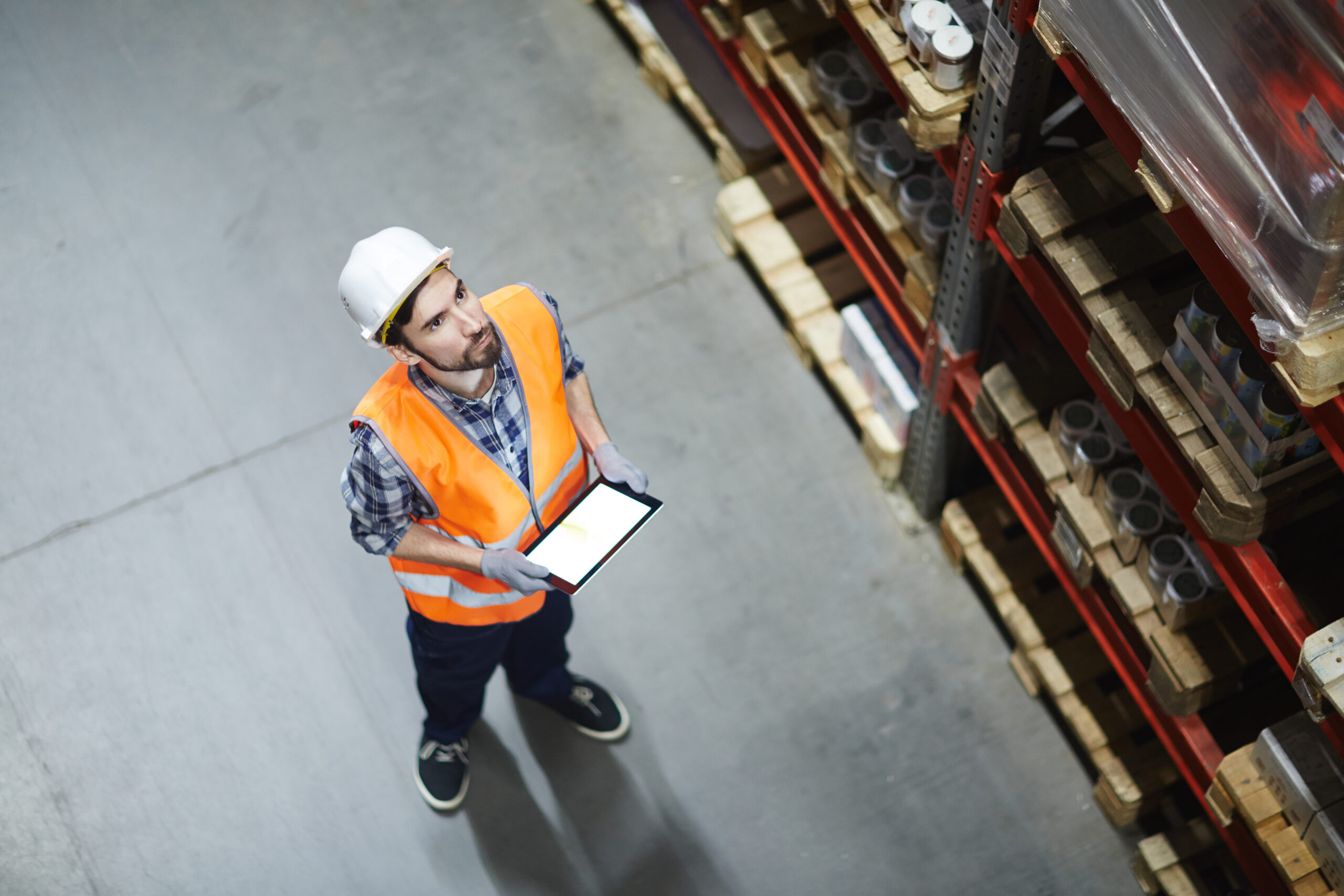 A worker in a warehouse using a tablet for order management.