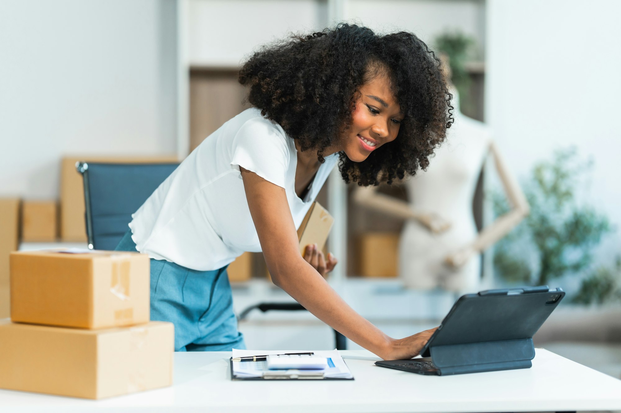 A young African American woman with afro brown hair works in modern office, management clothing